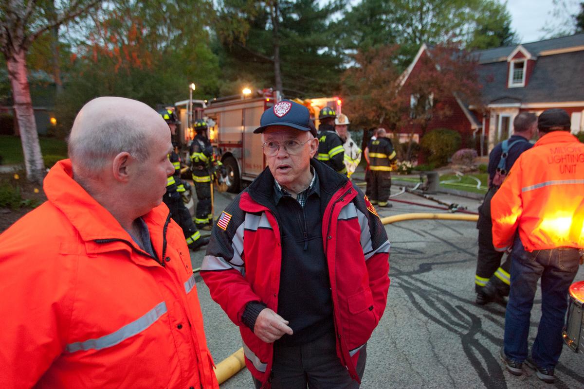 Two Men Talking with a Firetruck in the Background