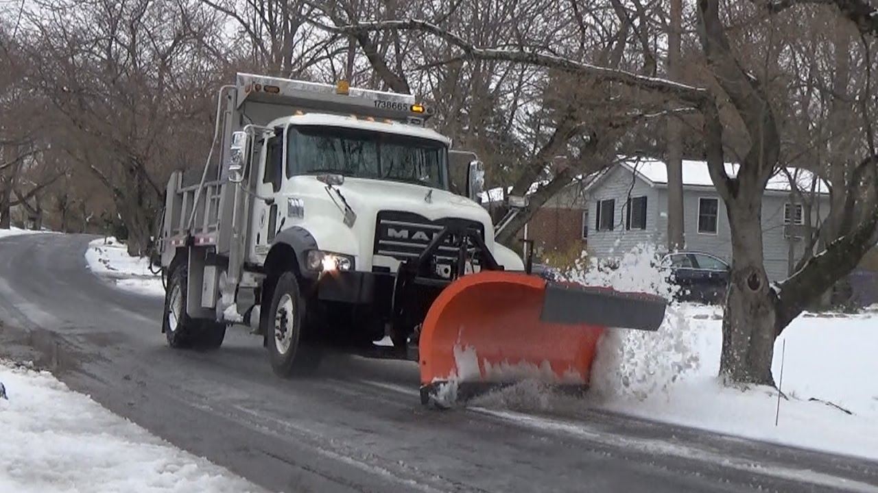 dump truck plowing snow on street